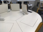 Circular desk containing PCs that pop up or fold flat